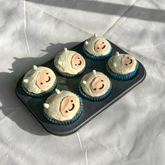 six cupcakes in the shape of pigs on a tray