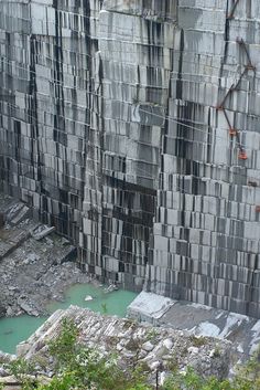 a man standing in front of a very tall building with lots of blocks on it