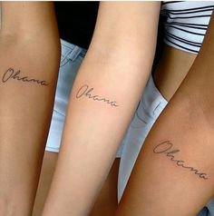 three girls with matching tattoos on their arms that say ohana and one girl has her name written in cursive writing