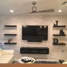 a living room filled with furniture and a flat screen tv mounted on the wall above it