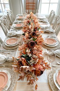 a long table is set with plates and place settings for an elegant fall dinner party