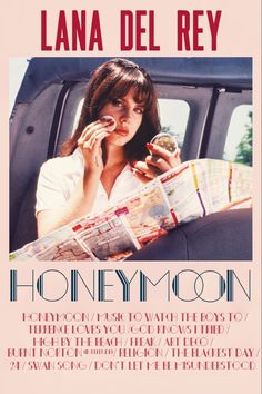 a woman sitting in the back seat of a car while reading a newspaper and eating a donut