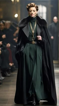 a woman walking down a runway wearing a green dress and black coat with fur collar