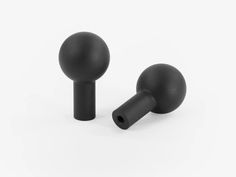 two black plastic knobs on a white background, one is turned to the side