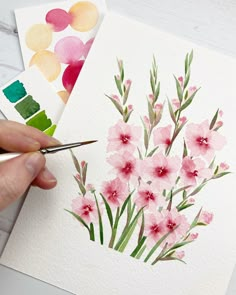 someone is painting flowers with watercolors on paper