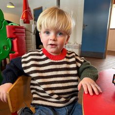 a young boy sitting at a table with a skateboard