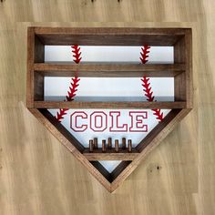 a wooden shelf with baseballs and the word cole on it