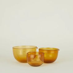 three yellow glass bowls sitting next to each other