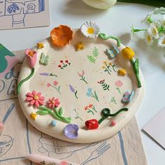 a white plate with flowers on it sitting on top of a table next to some scissors