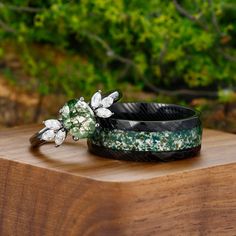 two bracelets sitting on top of a wooden table next to each other with flowers in them