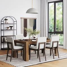 a dining room table with chairs and a rug on the floor