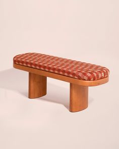 a wooden bench with a red and white checkered seat cushion on it's back