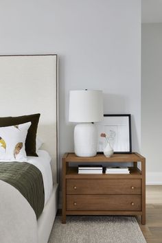 a bedroom with a bed, night stand and two lamps on the nightstands next to it