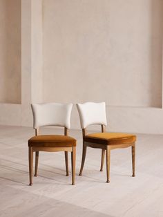 two chairs sitting side by side in an empty room