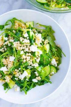 a salad with cucumbers and feta cheese in a white bowl