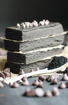 a piece of cake sitting on top of a white plate with chocolate chips around it