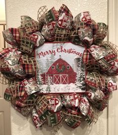 a red and green christmas wreath with a merry barn on it's front door