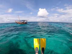 a kayak in the water with a boat in the background