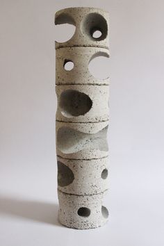 a tall white vase with holes in it