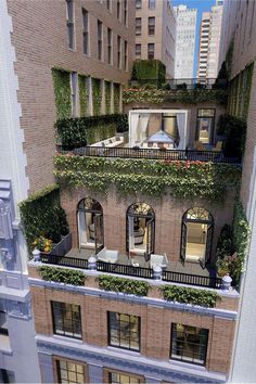 an apartment building with plants growing on the balconies