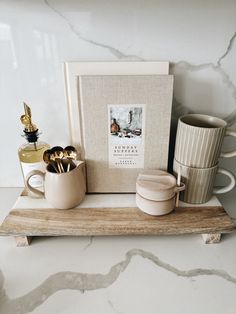 there are two mugs and some gold spoons on the counter next to each other