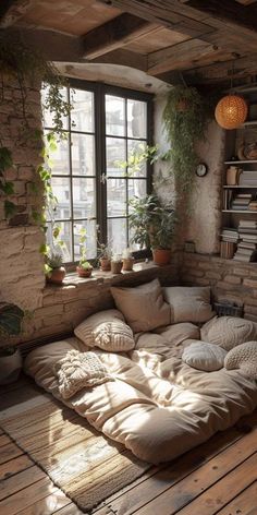 the sun shines through an open window into a room with large pillows and plants