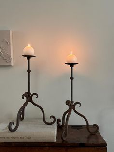 two candles are sitting on top of a table