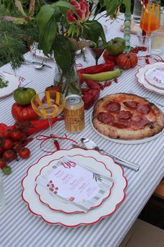 a table topped with plates and pizza covered in toppings on top of a table