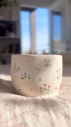 a white bowl sitting on top of a bed