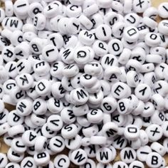 white and black letters are scattered on top of each other in the shape of beads