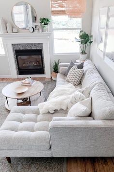 a living room filled with furniture and a fire place in the middle of the room