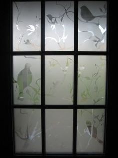 a window with frosted glass and birds on it