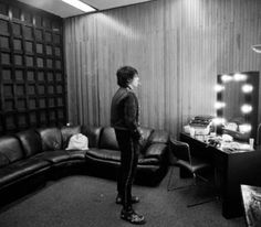 a man standing in front of a mirror next to a couch