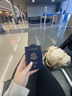 a person holding up a passport in an airport