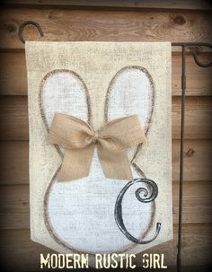 a towel hanging on the side of a building with a bow and monogrammed letters