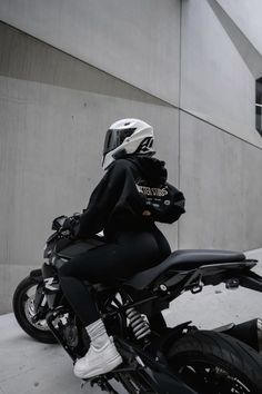 a person sitting on a motorcycle in front of a building