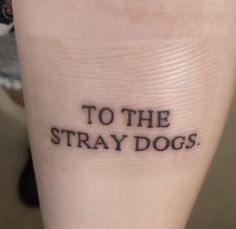 a person with a tattoo that says to the stray dogs