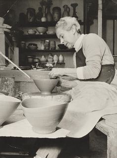 an old woman is making bowls on a potter's wheel