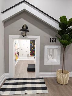 an entry way with a potted plant in the corner and pictures on the wall