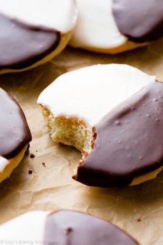 chocolate covered doughnuts with white frosting on brown parchment paper, ready to be eaten