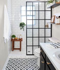 a bathroom with white tile and black accents