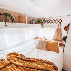 a bed with pillows and blankets in a small room