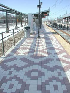 a train station platform with a bench next to it