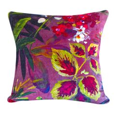 a purple pillow with red and yellow flowers on the front, and green leaves on the back