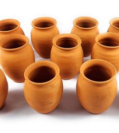 a group of nine clay vases sitting next to each other