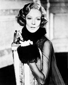 an old black and white photo of a woman in a fur stoler sitting on a chair