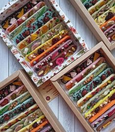 four wooden trays filled with different types of doughnuts and candies in them