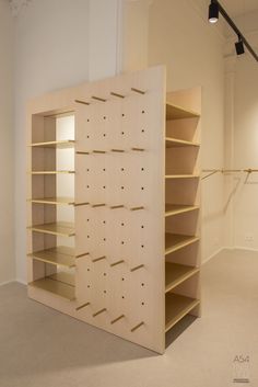 an empty room with shelving unit in the center and lights on either side of it