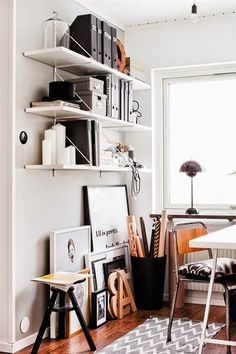 a white room with shelves and various items on the wall, including bookshelves