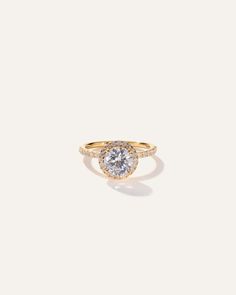 a yellow gold ring with a round diamond in the center